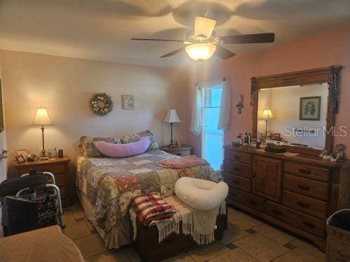 tiled bedroom featuring ceiling fan