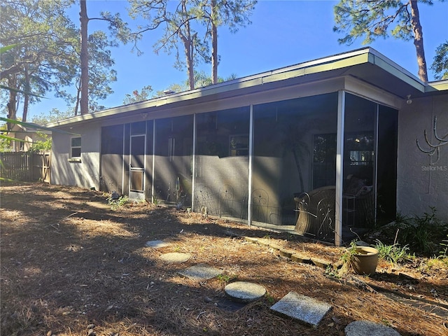 rear view of house featuring a sunroom