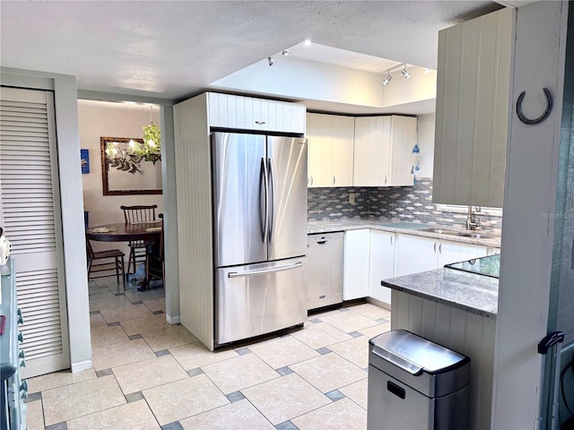 kitchen with sink, stainless steel fridge, dishwashing machine, decorative backsplash, and white cabinets