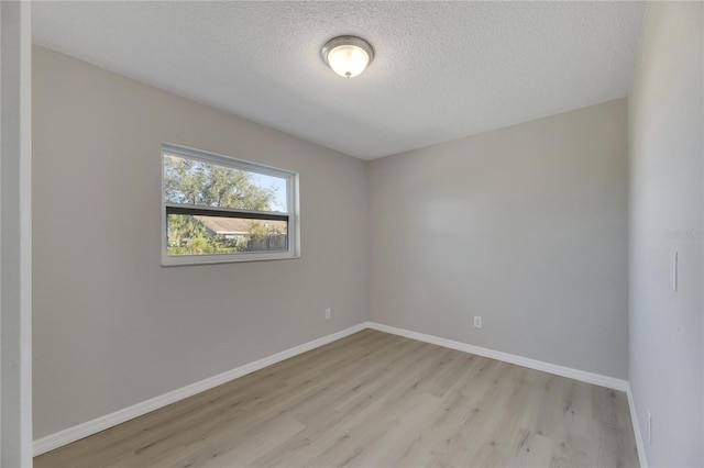 unfurnished room with a textured ceiling and light hardwood / wood-style flooring