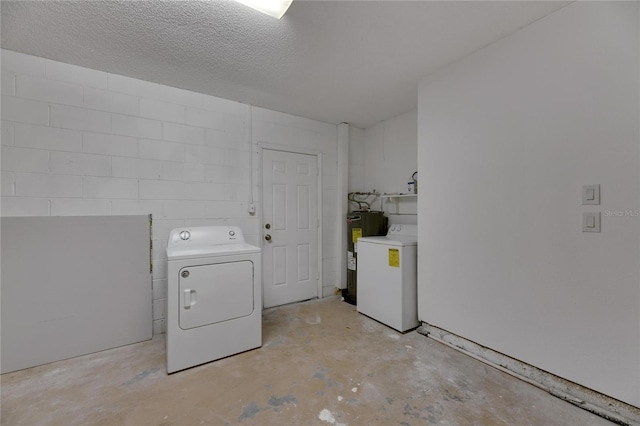 laundry room with electric water heater, a textured ceiling, and independent washer and dryer