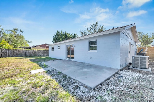 back of house featuring a yard, central AC, and a patio area