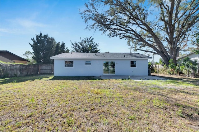 back of property featuring a yard and a patio