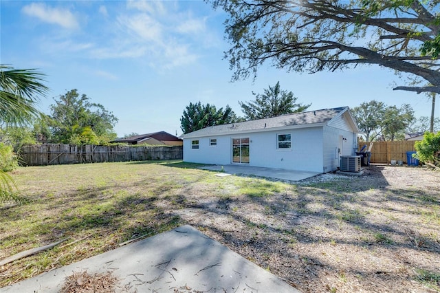 rear view of house featuring central air condition unit, a yard, and a patio