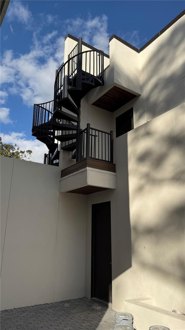 doorway to property featuring a balcony and stucco siding