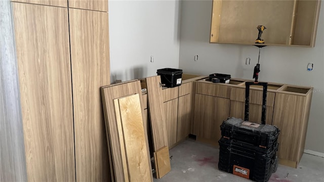 interior space with light brown cabinets, concrete floors, and modern cabinets