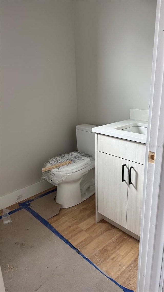 bathroom with vanity, toilet, and wood finished floors