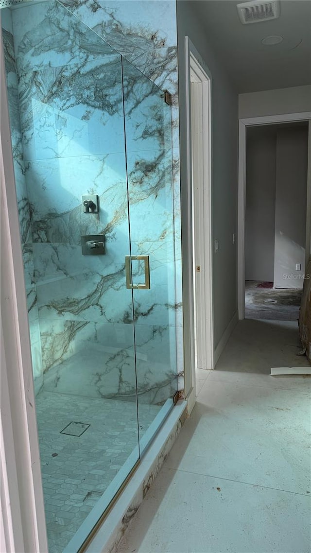 full bathroom with a marble finish shower and visible vents