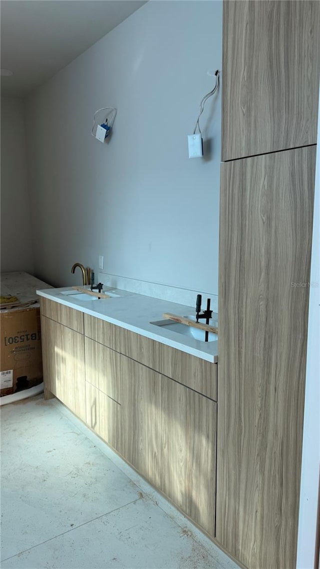 bathroom featuring a sink and double vanity