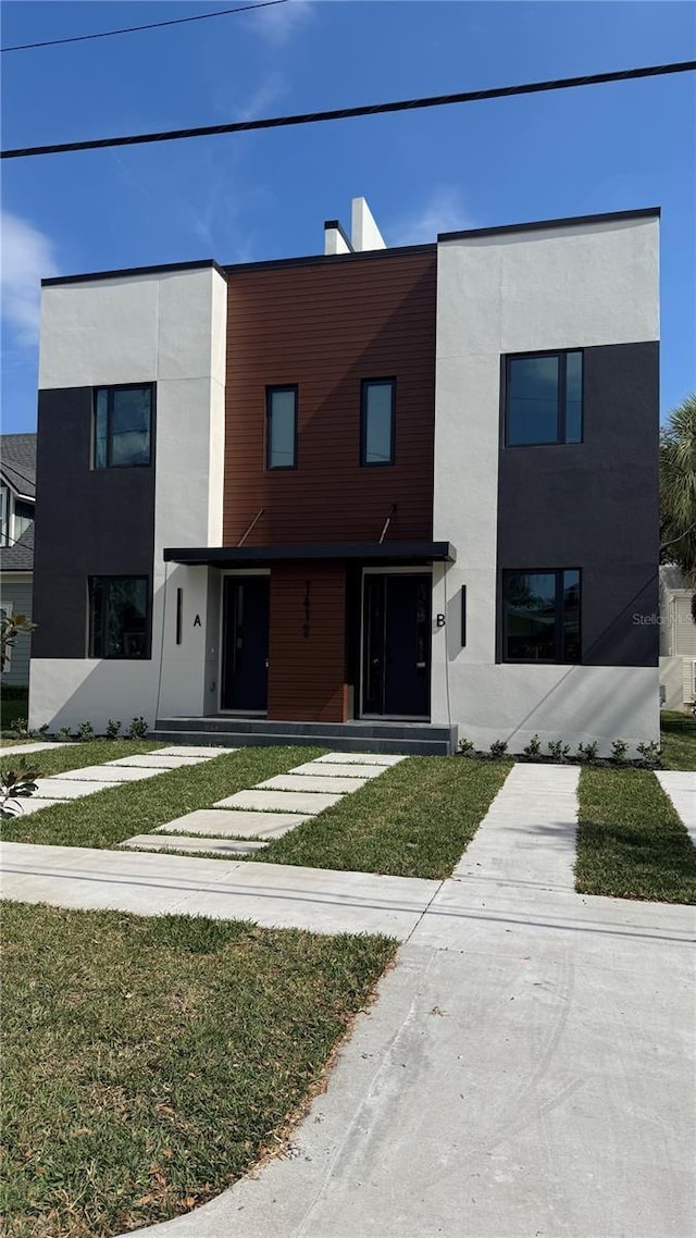 contemporary home with a front lawn and stucco siding