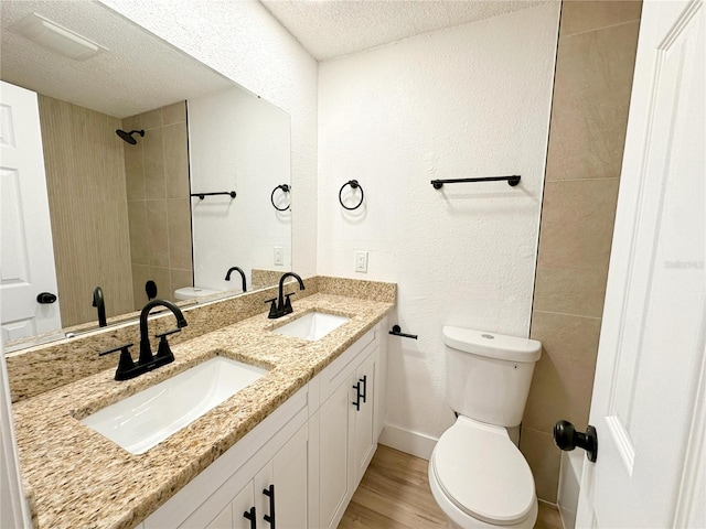 bathroom featuring toilet, vanity, a textured ceiling, and hardwood / wood-style floors