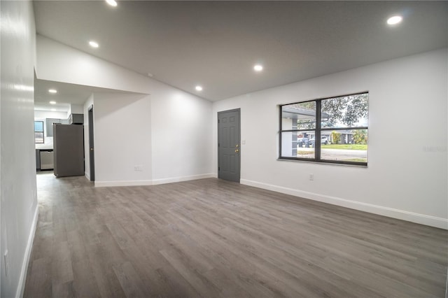 empty room featuring lofted ceiling and dark hardwood / wood-style floors