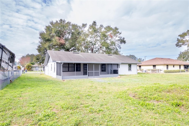 back of house featuring a yard and a sunroom