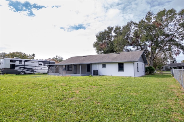 back of property featuring central AC unit and a yard