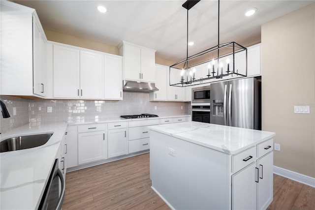 kitchen with sink, white cabinets, stainless steel appliances, and a kitchen island