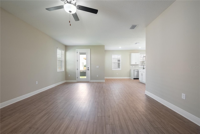 unfurnished living room with hardwood / wood-style flooring and ceiling fan