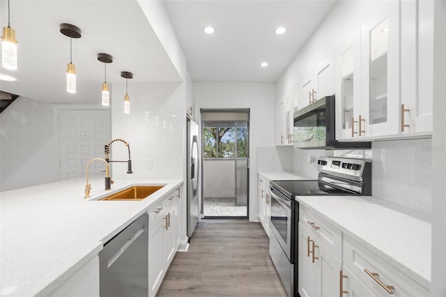 kitchen featuring hardwood / wood-style floors, sink, white cabinetry, and stainless steel appliances