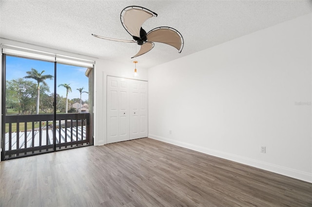 spare room with ceiling fan, hardwood / wood-style floors, and a textured ceiling