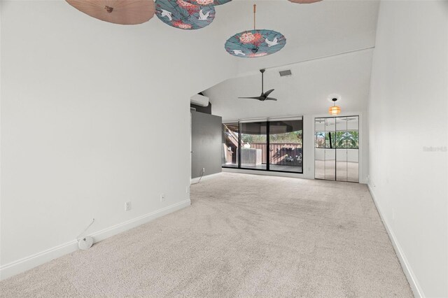 unfurnished living room with carpet flooring, ceiling fan, and vaulted ceiling