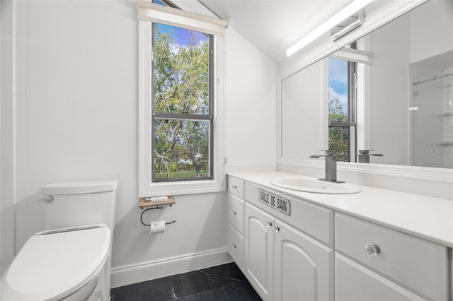 bathroom with tile patterned flooring, vanity, a healthy amount of sunlight, and toilet