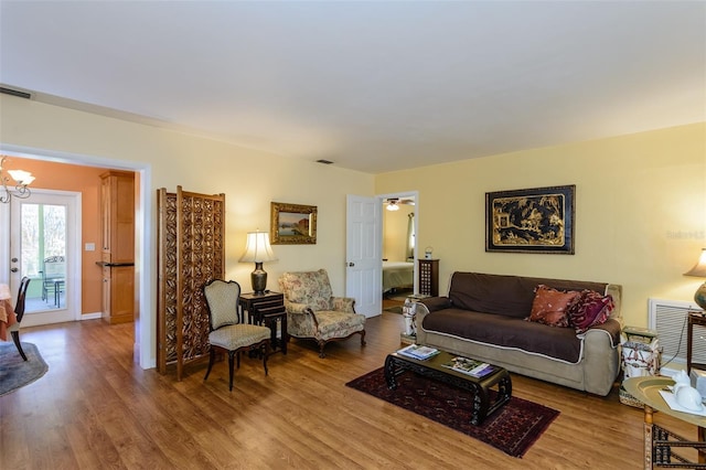 living room featuring french doors, a chandelier, and hardwood / wood-style flooring