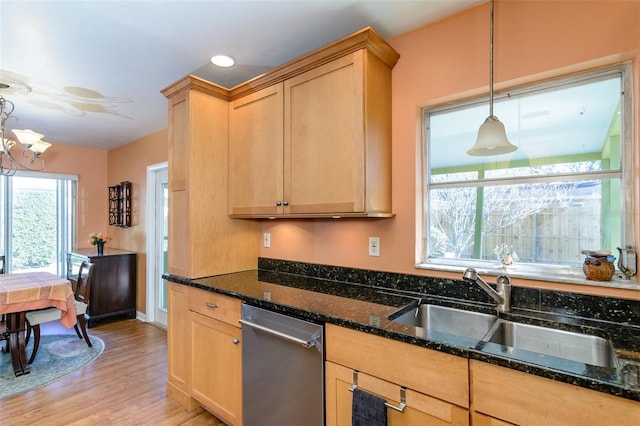 kitchen featuring light brown cabinets, sink, hanging light fixtures, light hardwood / wood-style flooring, and dark stone counters