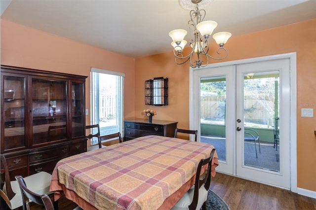 dining area with dark hardwood / wood-style floors, a healthy amount of sunlight, an inviting chandelier, and french doors