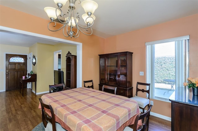 dining room with dark wood-type flooring and a notable chandelier