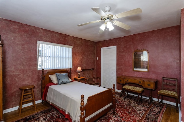 bedroom with a closet, dark hardwood / wood-style floors, and ceiling fan