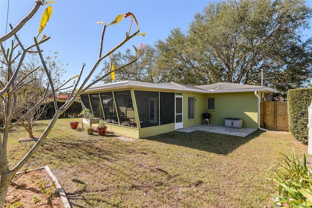 rear view of property with a yard, a patio area, and a sunroom