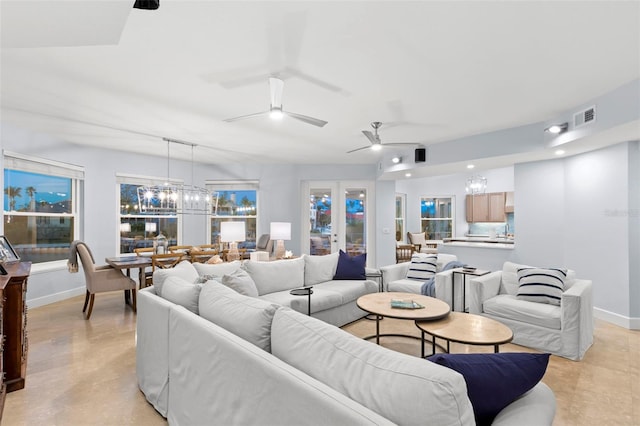 living room featuring ceiling fan with notable chandelier