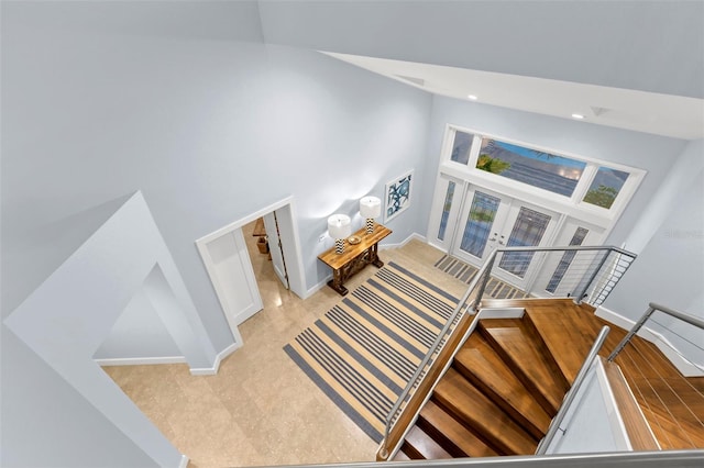 staircase featuring french doors and a towering ceiling