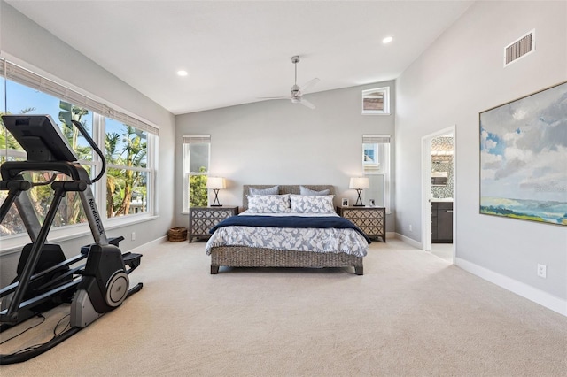 bedroom with ceiling fan, lofted ceiling, ensuite bathroom, and light carpet