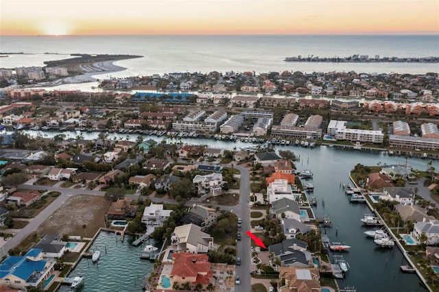 aerial view at dusk featuring a water view