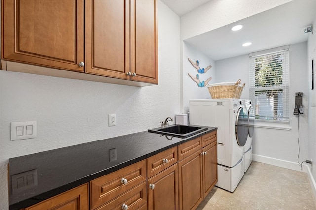 laundry room featuring cabinets, sink, and washing machine and dryer