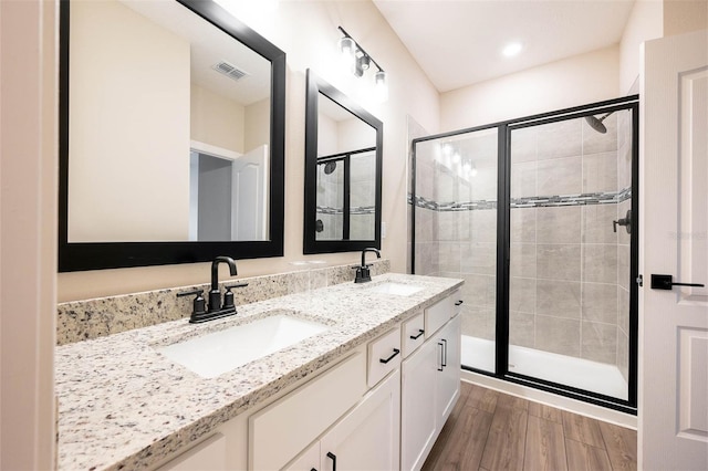 bathroom featuring vanity, wood-type flooring, and walk in shower