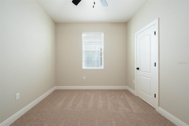 carpeted spare room with ceiling fan