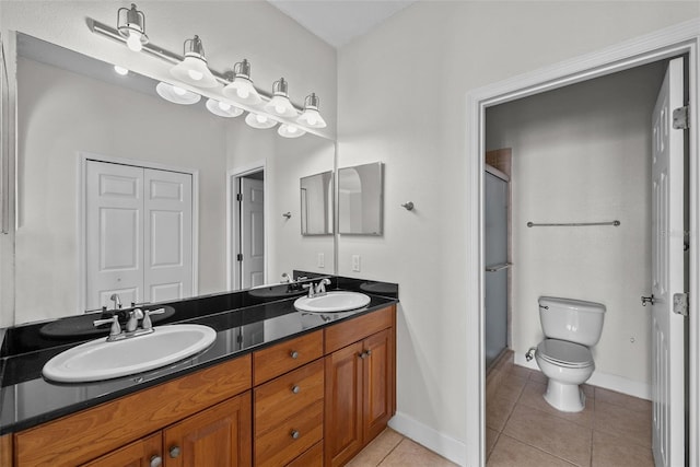 bathroom with a shower with door, vanity, tile patterned floors, and toilet