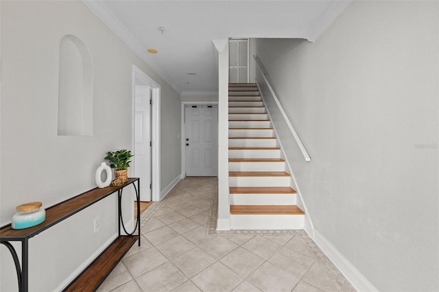 stairs with crown molding and tile patterned floors