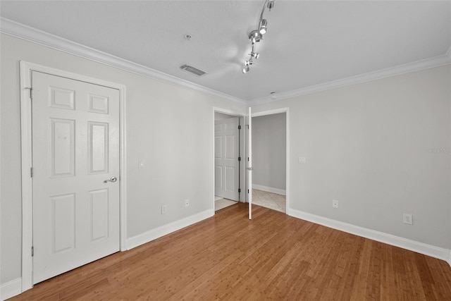 unfurnished bedroom featuring wood-type flooring and crown molding