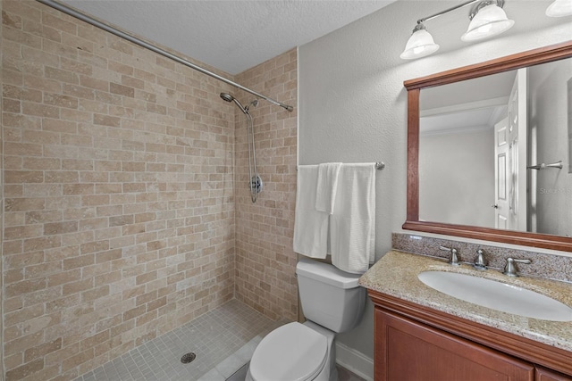 bathroom with vanity, a textured ceiling, toilet, and tiled shower