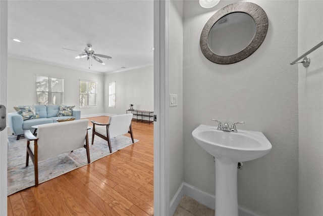 bathroom featuring sink, crown molding, wood-type flooring, and ceiling fan