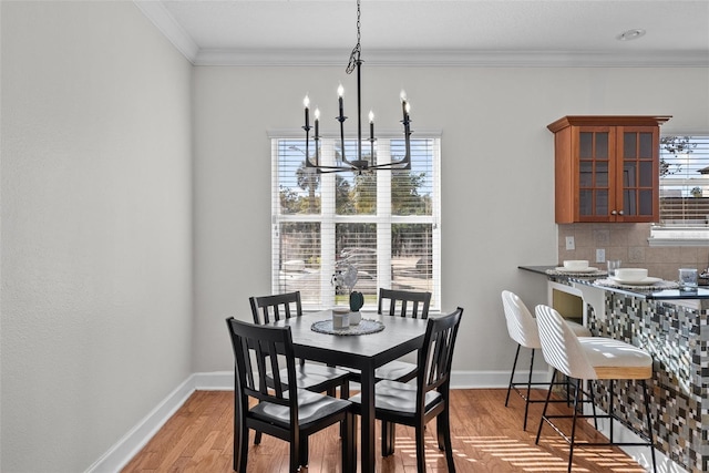 dining space featuring ornamental molding, plenty of natural light, light hardwood / wood-style flooring, and a notable chandelier