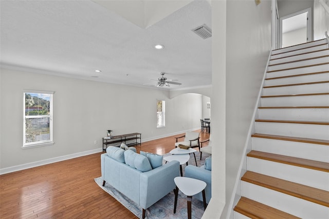 living room with ceiling fan, wood-type flooring, and a textured ceiling