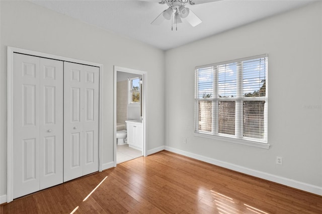 unfurnished bedroom with ceiling fan, a closet, ensuite bath, and light hardwood / wood-style flooring