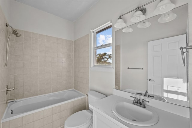 full bathroom with tiled shower / bath, vanity, and toilet