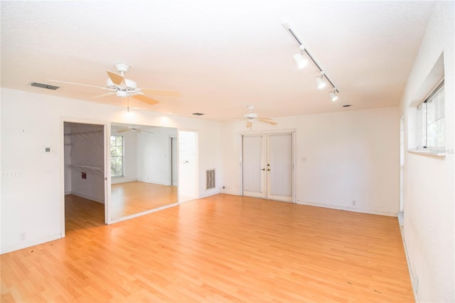 empty room featuring rail lighting and light hardwood / wood-style flooring