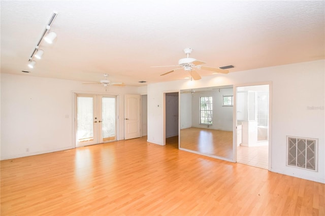 spare room with ceiling fan, french doors, rail lighting, and light hardwood / wood-style flooring