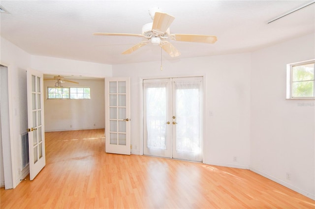 spare room with ceiling fan, french doors, and light wood-type flooring