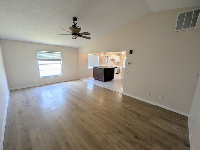 spare room with light hardwood / wood-style flooring, ceiling fan, and lofted ceiling